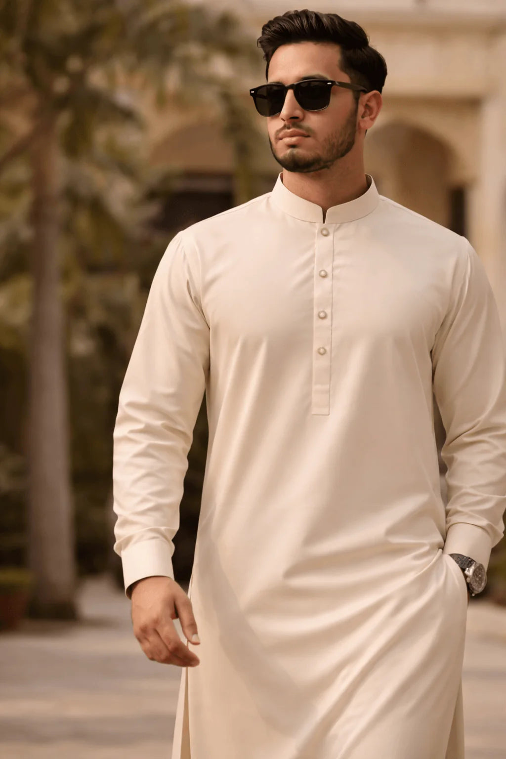 Man wearing a cream kurta with sunglasses outdoors