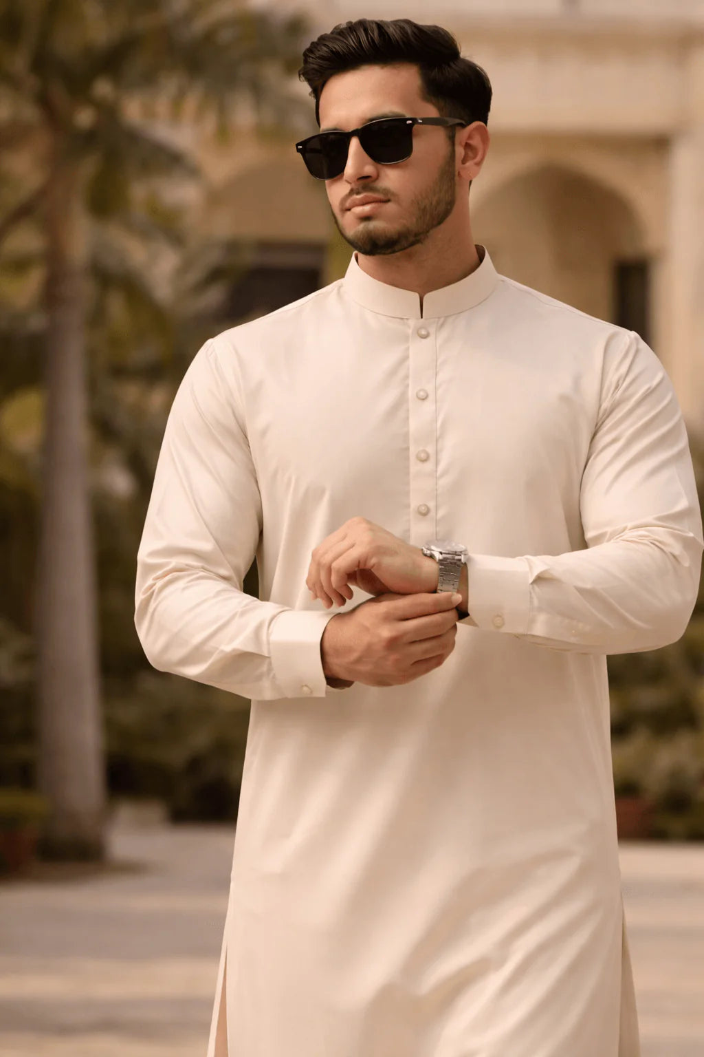 Man wearing a cream kurta with sunglasses outdoors